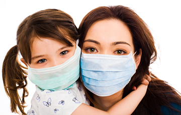 woman and young child wearing surgical masks
