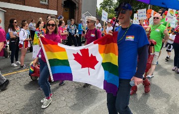 people marching in pride parade holding flag