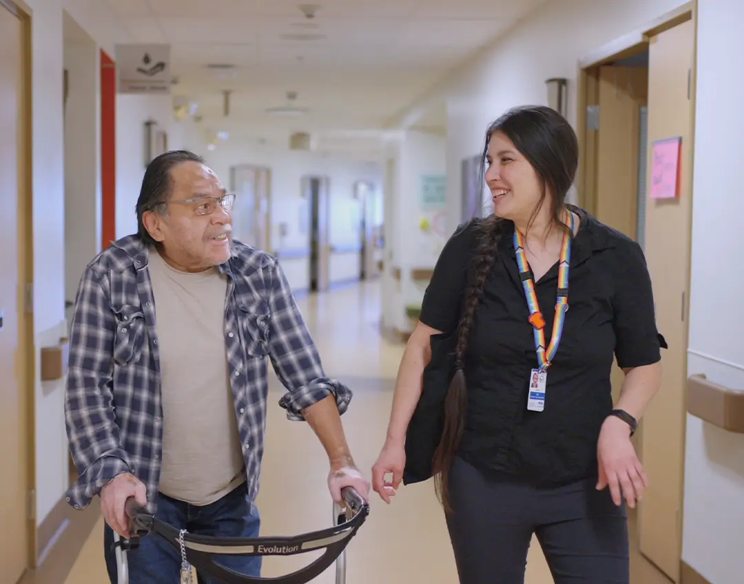 Nurse chatting with a patient in hospital corridor