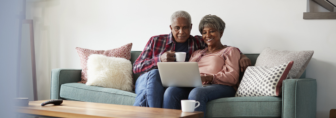 couple using laptop on couch