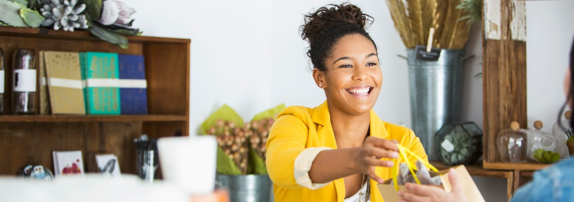 Woman handing purchase to customer