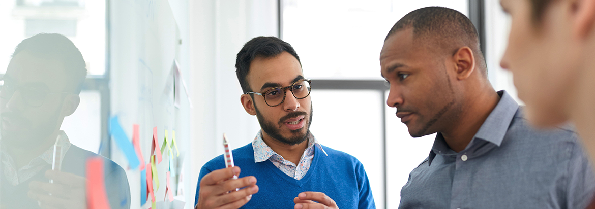 Three guys in front of a whiteboard