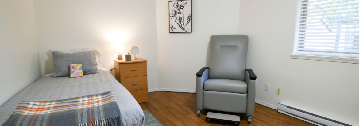 Room with a bed, side table and arm chair