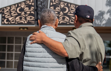 Noel and his father, Elder Gary Brown, watch the unveiling of Noel's commissioned art for NRGH