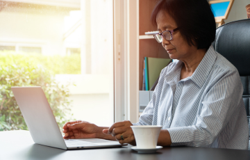 woman with glasses working on a laptop
