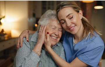 two women smiling and in a supportive embrace