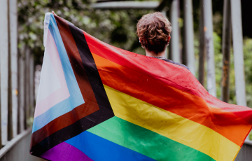 Person holding trans inclusive flag