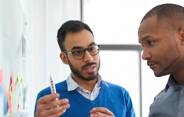 Three guys in front of a whiteboard