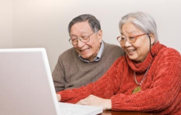 Man and woman smiling while looking at computer screen