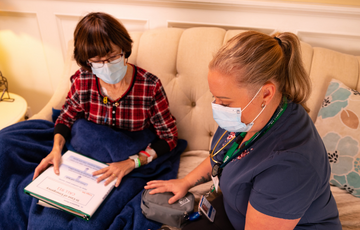 nurse and patient looking at chart on a couch