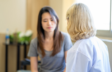 female patient seated talking with health care provider 