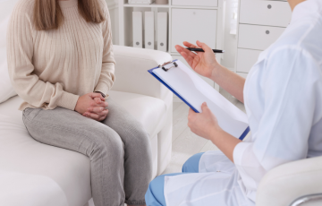 female patient seated talking with health care provider 