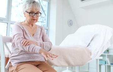 adult female patient sitting on hospital bed in her everyday clothes