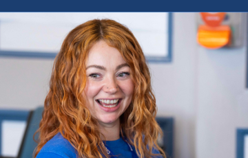 woman with red hair in blue t shirt smiling