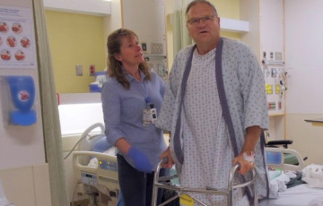 Dan Kelly using a walker in hospital