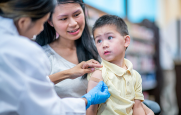 Child receiving immunization from care provider