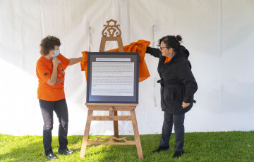 People unveiling a truth and reconciliation plaque.