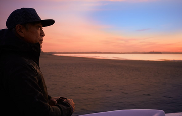 Man looking at a sunset on a beach