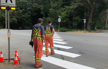 Two people cross a new cross walk in Metchosin