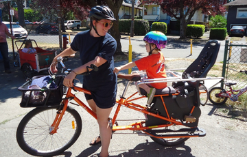 Parent and child riding a bike together 