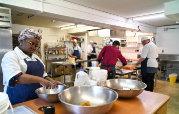 people cooking in a large training kitchen