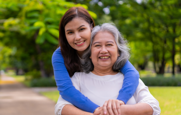 Young woman hugging older woman and smiling