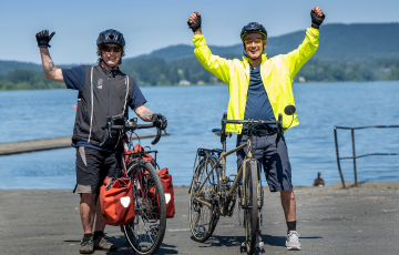 two people with bikes waving