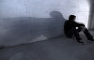 youth sitting alone against wall