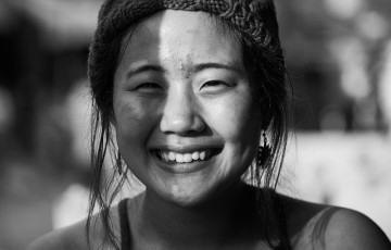 female asian youth wearing hat smiling